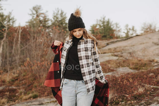 Young woman putting on second shirt during autumn hike — Stock Photo