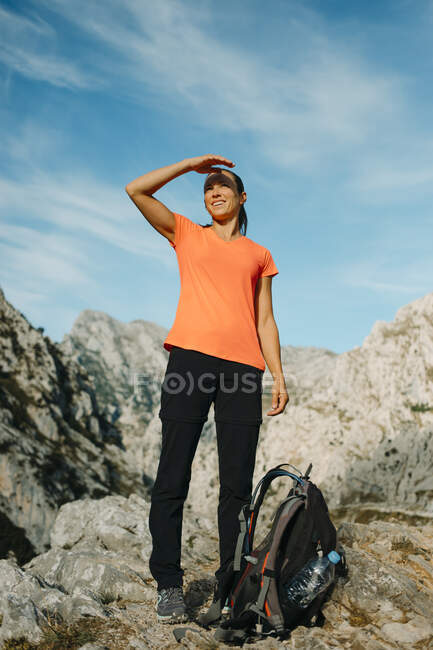 Женщина экранирует глаза, глядя на вид, стоящий на горе в Cares Trail в Национальном парке Пикос-де-Европа, Астурия, Испания — стоковое фото
