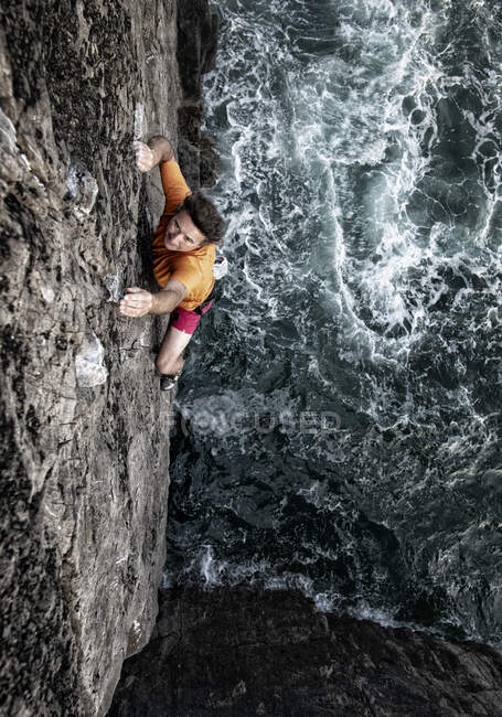 Scalatore di roccia maschio determinato arrampicatore via mare — Foto stock