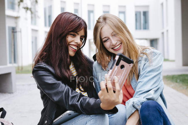 Fröhliche junge Studentinnen machen Selfie auf dem Campus — Stockfoto