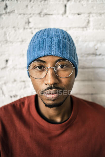 Smiling man wearing eyeglasses against white brick wall — Stock Photo