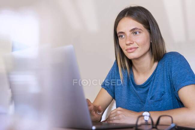 Professionista femminile utilizzando il computer portatile mentre si lavora a casa — Foto stock