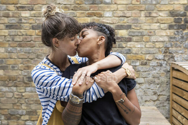 Coppia lesbica baciarsi mentre in piedi nel cortile posteriore — Foto stock