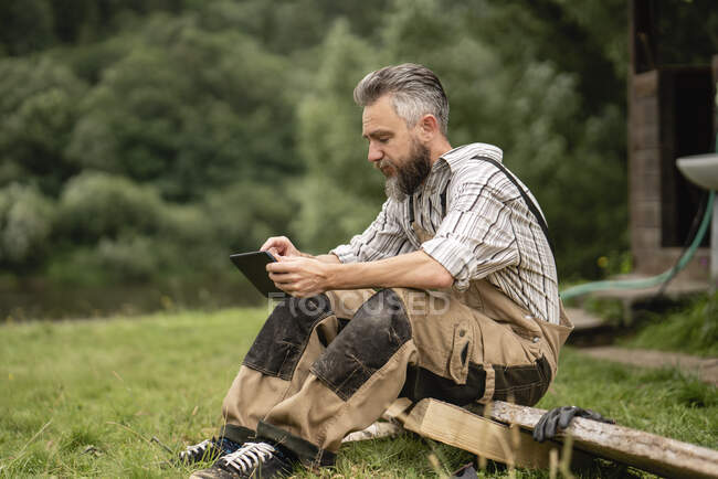 Carpintero usando tableta digital durante el descanso - foto de stock