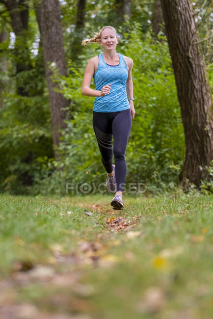 Attiva atleta femminile che fa jogging nella foresta — Foto stock