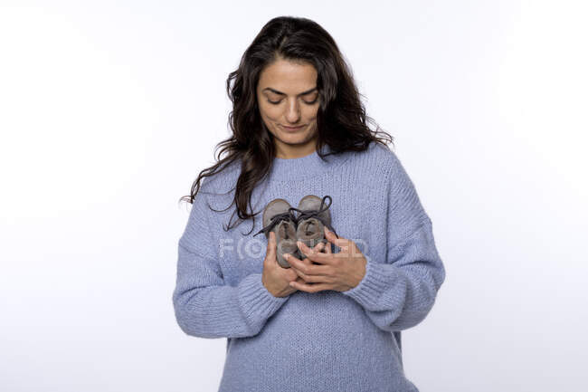Frau mit Babystiefeln vor weißem Hintergrund — Stockfoto