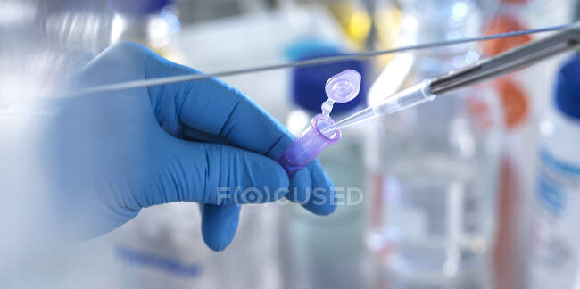 Scienziato maschio pipettatura formula chimica in flaconcino in laboratorio — Foto stock