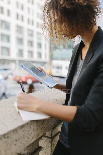 Молода бізнес-леді пише в щоденнику за допомогою цифрового планшета. — стокове фото