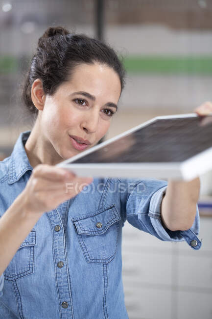 Бізнес-леді тримає модель сонячної панелі в офісі — стокове фото
