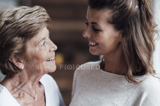 Glückliche Großmutter und junge Frau schauen einander an — Stockfoto