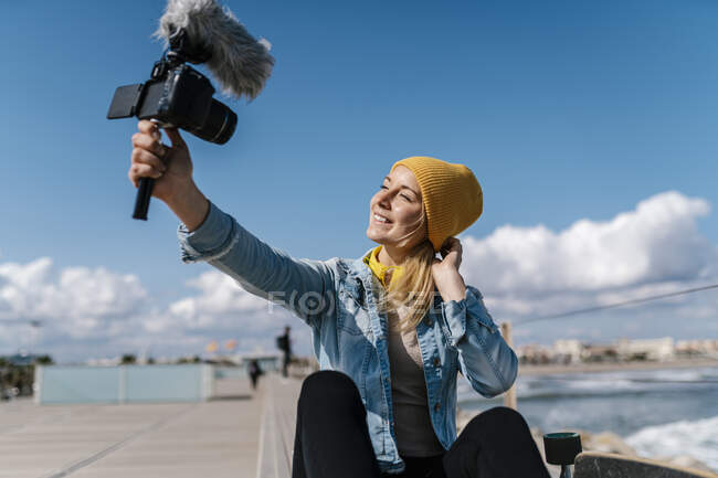 Felice donna in camicia denim registrazione video attraverso la fotocamera durante il fine settimana — Foto stock