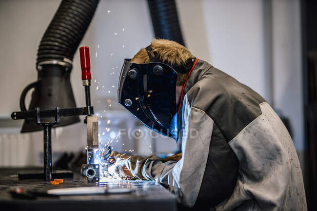 Welder with coveralls working at factory — Stock Photo