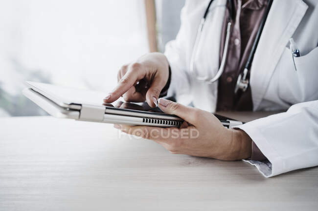 Жінка-лікар використовує цифровий планшет за столом у лікарні — стокове фото