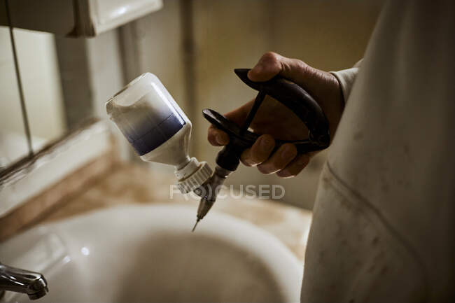 Ragazzo adolescente che tiene la siringa sopra il lavandino del bagno in fattoria — Foto stock