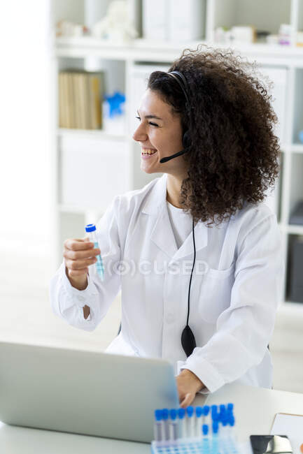 Scienziata che sorride con la provetta mentre lavora in laboratorio — Foto stock