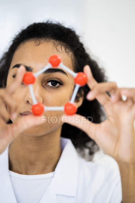 Chercheuse à travers la structure moléculaire en laboratoire — Photo de stock