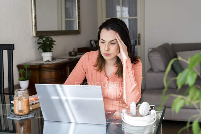 Стурбована жінка-підприємець працює вдома на ноутбуку. — стокове фото