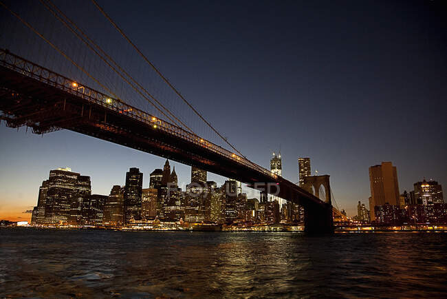 EUA, Nova York, Nova York, Brooklyn Bridge à noite com horizonte de Manhattan no fundo — Fotografia de Stock