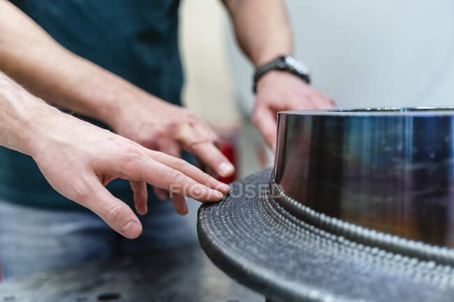 Male engineers touching machinery at factory — Stock Photo