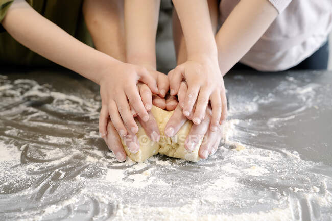 Padre e hijos amasando masa juntos en la isla de la cocina — hornear, padres  - Stock Photo | #482792408