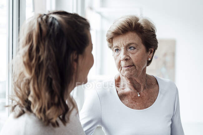 Grave nonna guardando nipote a casa — Foto stock