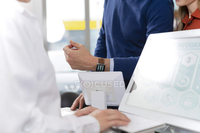 Cliente masculino que paga con reloj inteligente en la farmacia - foto de stock