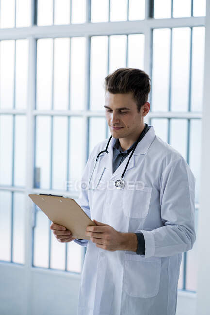 focused_482793490-stock-photo-male-doctor-looking-documents-while.jpg