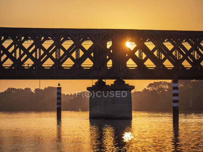 Silhouette of bridge stretching over river Rhone at sunset, Vaucluse, France — Stock Photo