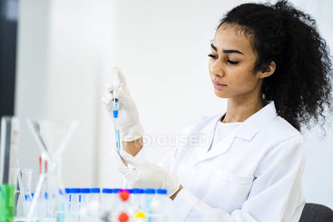 Giovane ricercatrice che inietta liquido in provetta in laboratorio — Foto stock
