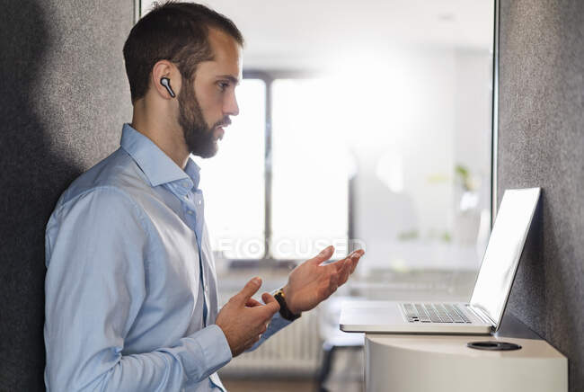Homme d'affaires gestuelle tout en parlant sur appel vidéo sur ordinateur portable au bureau — Photo de stock