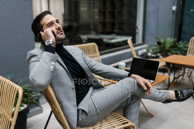 Mitte erwachsener Geschäftsmann telefoniert während er im Café sitzt — Stockfoto