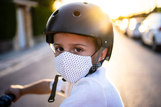 Menino em máscara protetora e capacete durante o pôr do sol — Fotografia de Stock