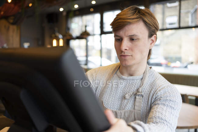Homme d'affaires ajustement de l'ordinateur du restaurant pendant la journée — Photo de stock