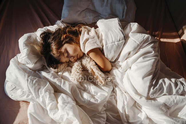 Dolce bambina che dorme in camper con giocattolo di coniglio ripieno — Foto stock