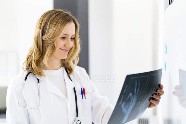 Улыбающаяся женщина-врач проводит рентген в медицинской клинике — стоковое фото
