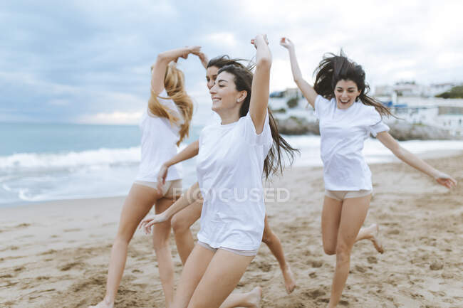 Весёлые подруги веселятся на пляже во время отпуска — стоковое фото