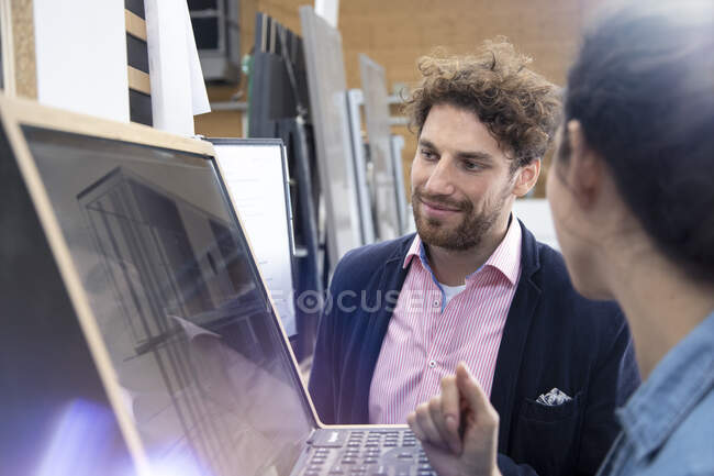 Male and female entrepreneurs discussing over control panel at factory — Stock Photo