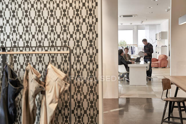 Female discussing with males at clothes design studio — Stock Photo