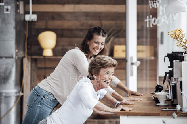 Cheerful senior woman with granddaughter exercising at countertop — Stock Photo