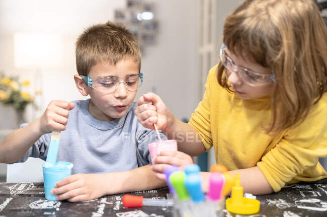 Mädchen mit bruder herstellung schleim bei zuhause — Stockfoto