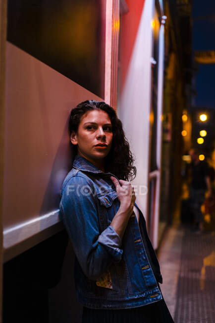 Ragazza premurosa appoggiata al muro in città di notte — Foto stock