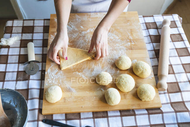 Woman making dough balls on cutting board to make croissants in kitchen — Stock Photo