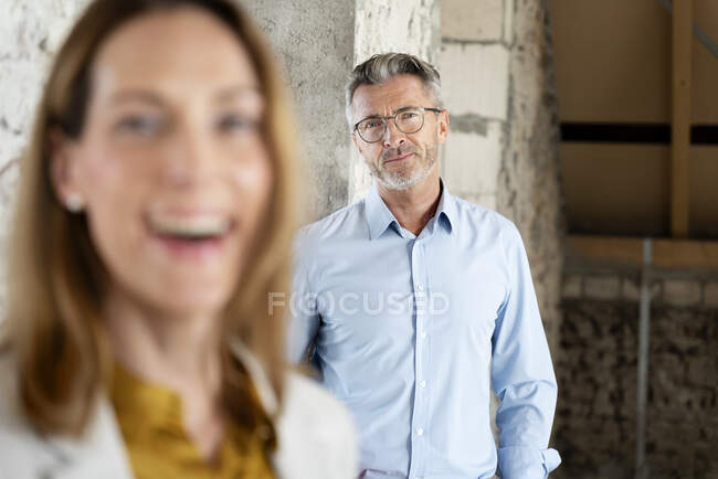 Mature architect staring while standing with businesswoman at construction site — Stock Photo