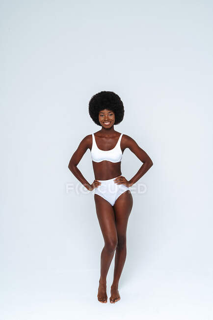 Skinny female model wearing bikini standing against white background —  individuality, hair - Stock Photo | #484387382