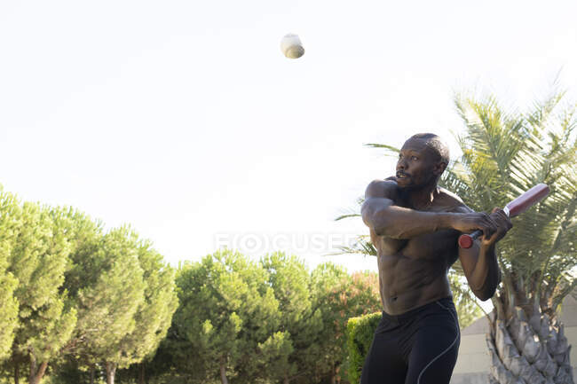 Африканський спортсмен грає з бейсболом у парку. — стокове фото