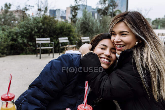 Young woman hugging her female friend — Stock Photo