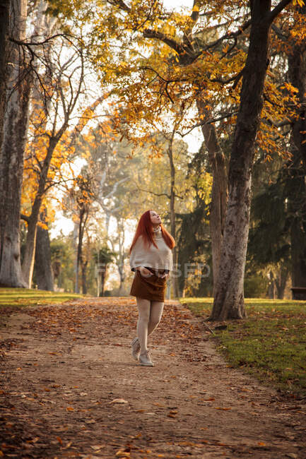 Frau läuft im Herbst auf Fußweg in Park — Stockfoto