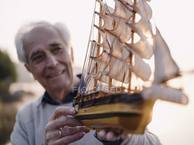 Homem segurando brinquedo navio enquanto está ao ar livre — Fotografia de Stock