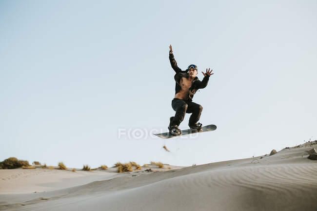 Sandboarding uomo su dune di sabbia ad Almeria, nel deserto di Tabernas, Spagna — Foto stock
