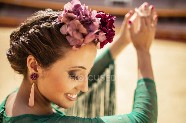 Close-up of flamenco dancer wearing flowers clapping her hands — Stock Photo